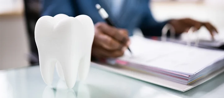 Dentist doing paper work with tooth icon
