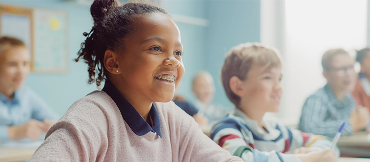 Young girl smiling with braces in school
