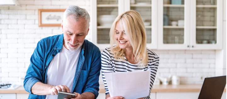 A middle age couple looking at their dental insurance in their kitchen