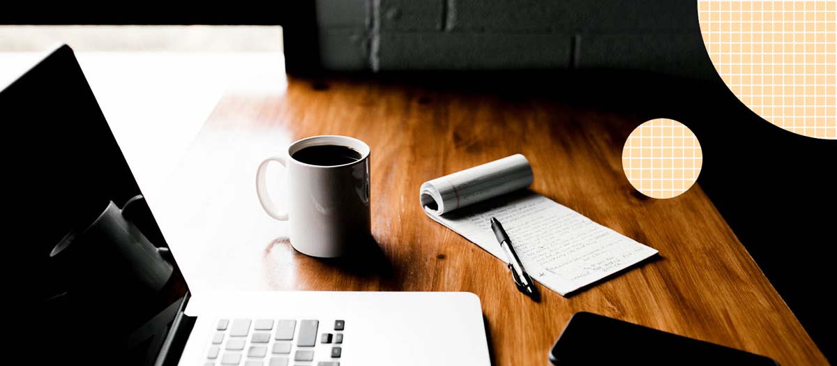 Computer, coffee cup, and notepad on deck