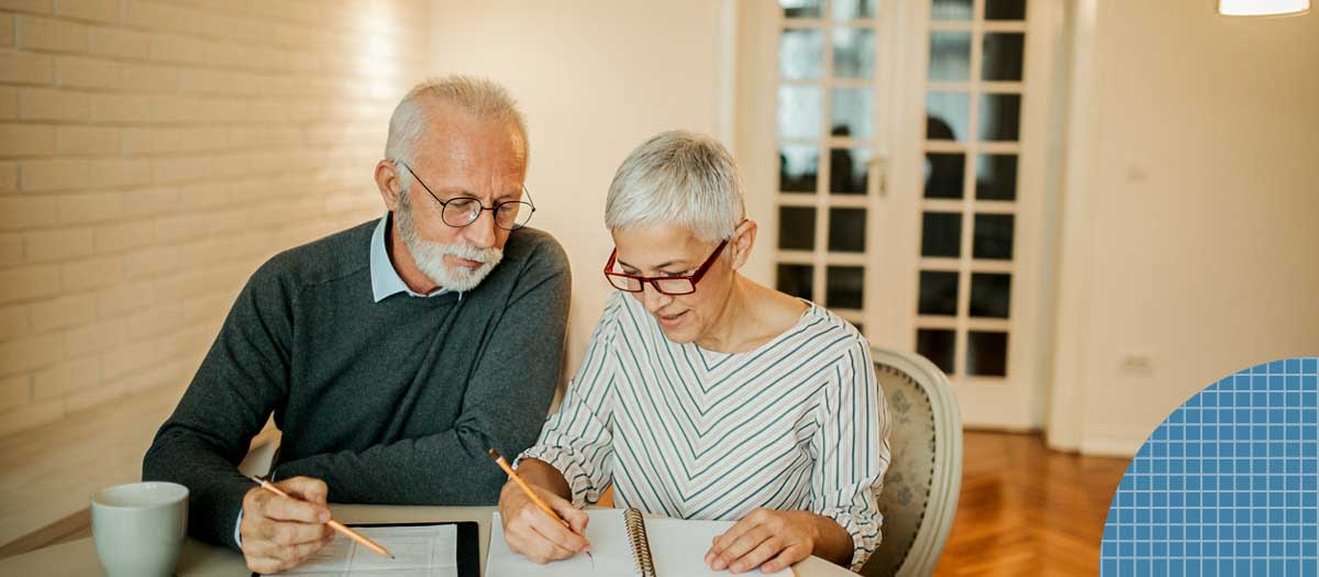 Senior couple going over paperwork in dining room