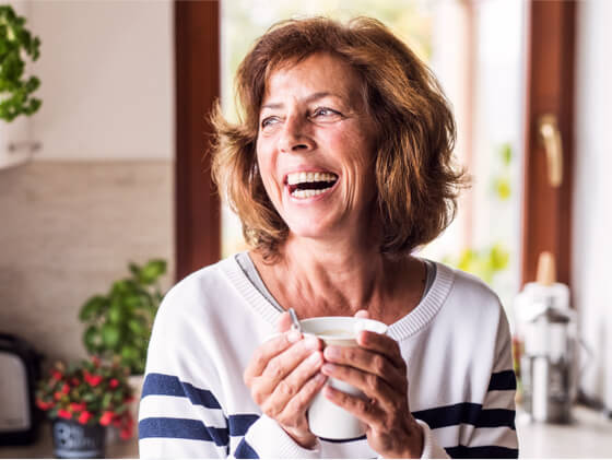 A woman smiling with affordable dental coverage